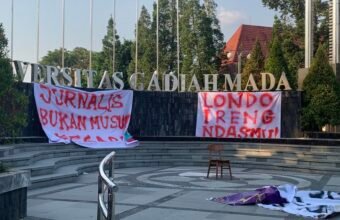 Spanduk 'Londo Ireng Ndasmu' dan 'Jurnalis Bukan Musuh' dibentangkan di Bundaran UGM, Minggu (26/7/2026) oleh Koalisi Persma DIY.